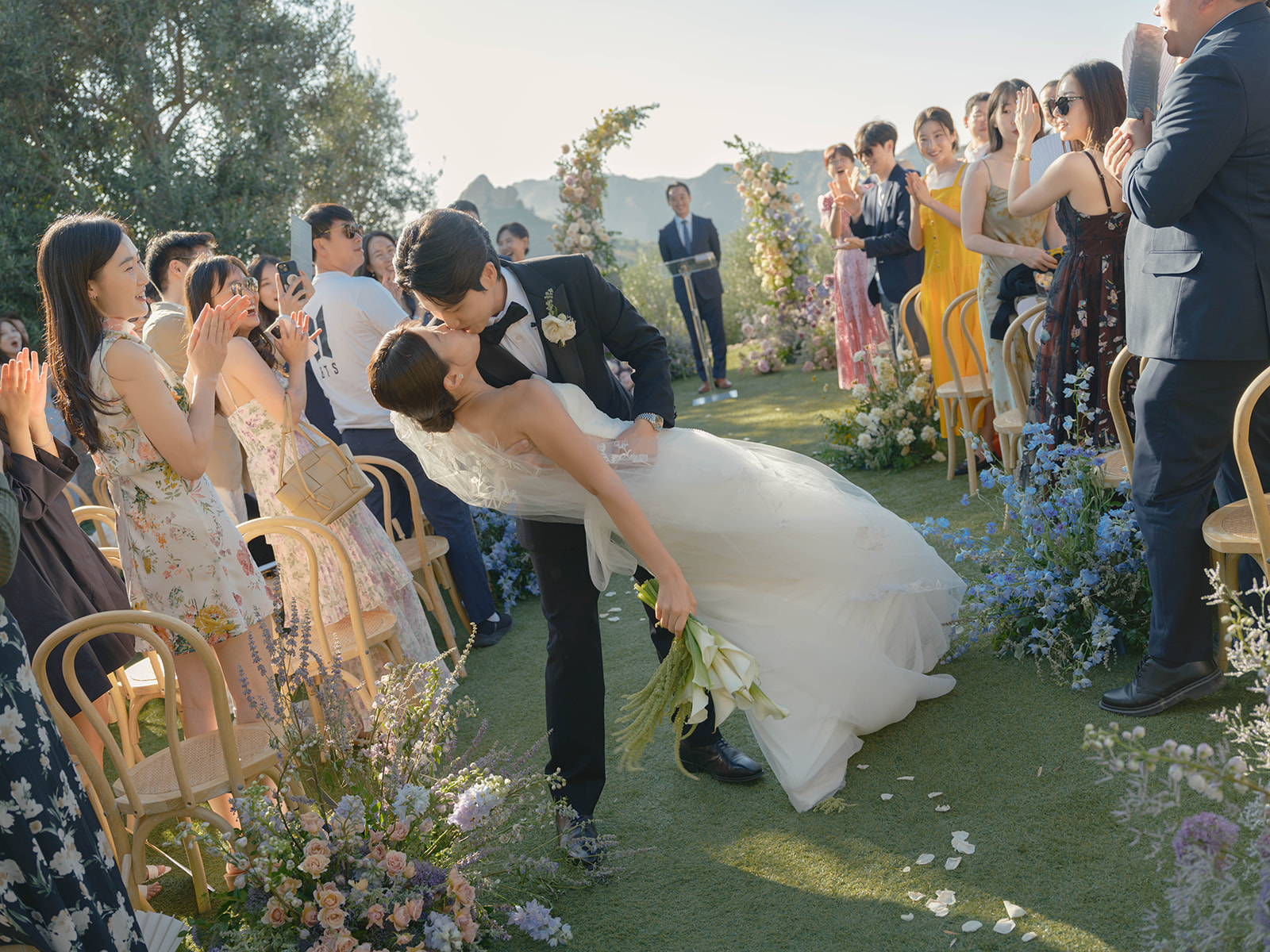 Groom dipping bride for a kiss after their laidback luxury Malibu wedding ceremony
