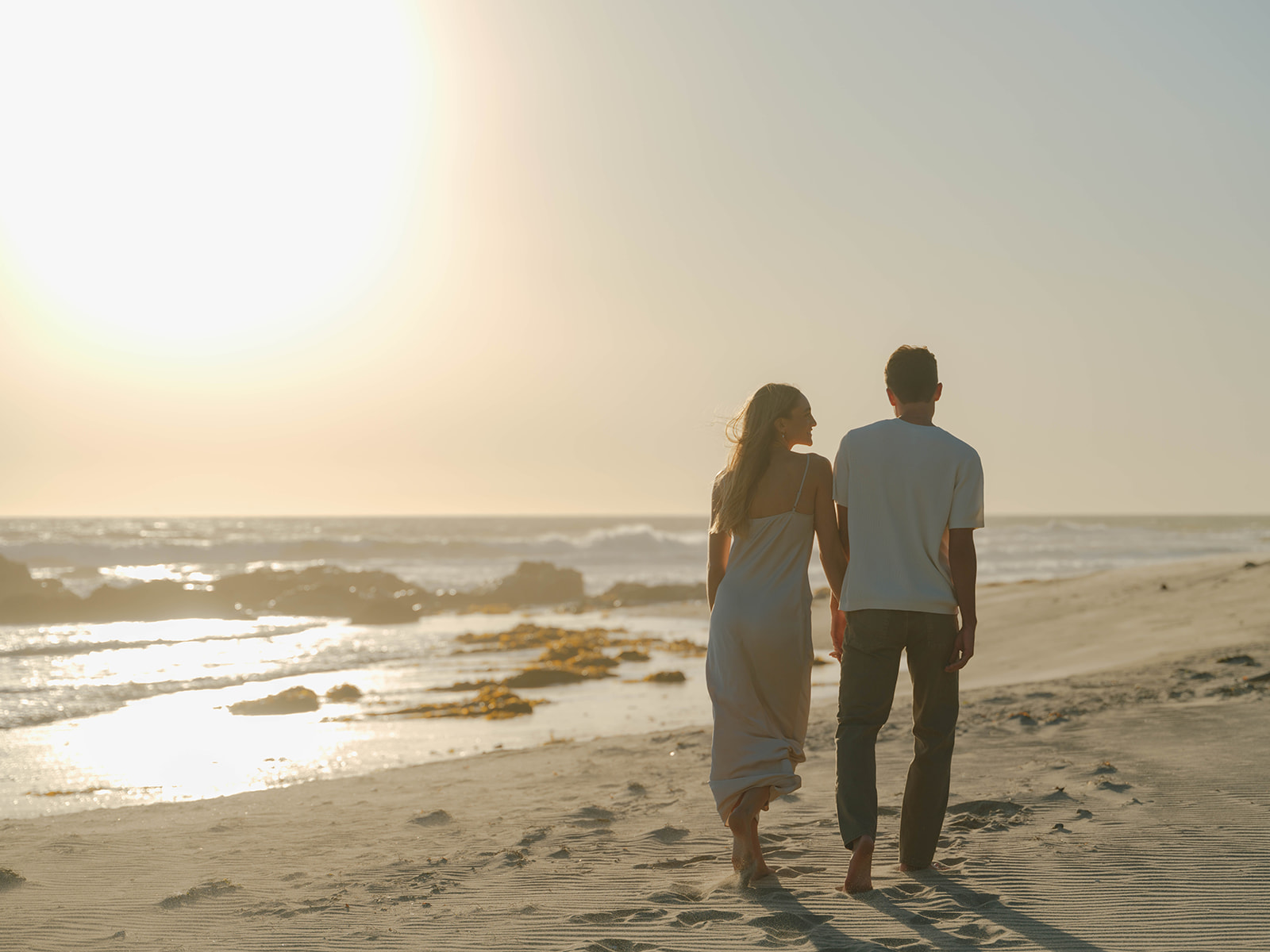 Couple walking along beach during Santa Barbara engagement session